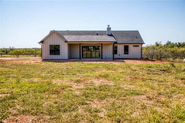 rear view of property featuring a lawn