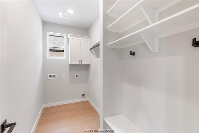 washroom with hardwood / wood-style floors, hookup for an electric dryer, cabinets, and washer hookup