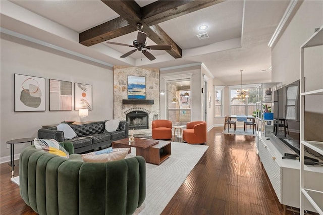 living area featuring baseboards, visible vents, coffered ceiling, dark wood-style flooring, and a stone fireplace