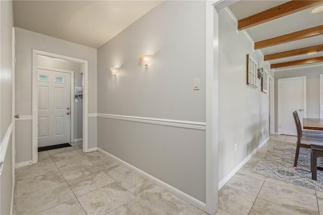 hall with beamed ceiling, tile patterned floors, and baseboards