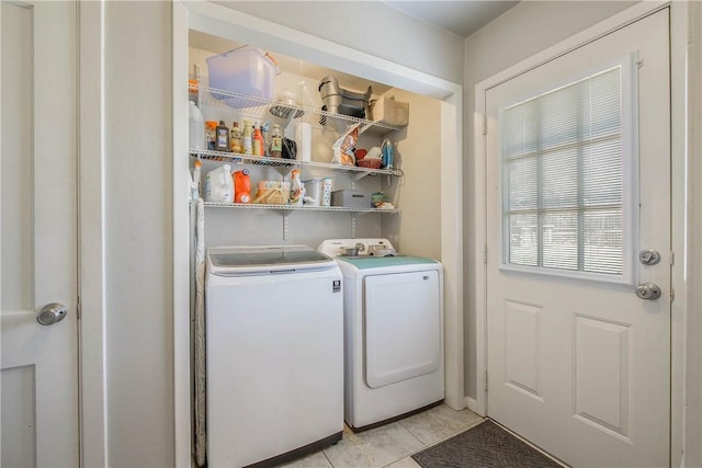 clothes washing area with washer and dryer, laundry area, and light tile patterned floors