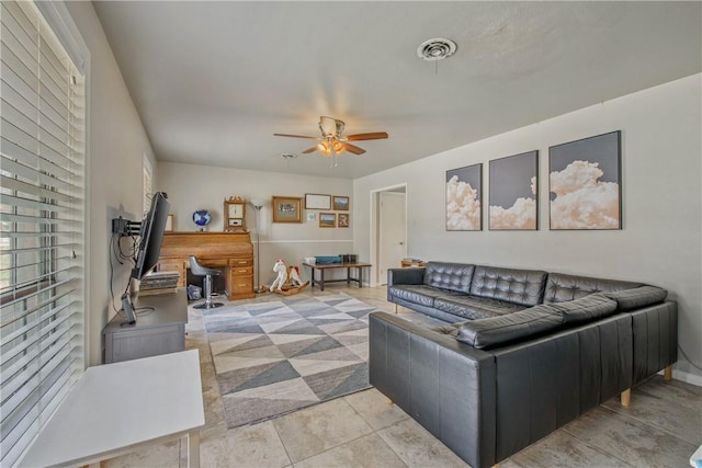 living room with light tile patterned floors, baseboards, visible vents, and a ceiling fan