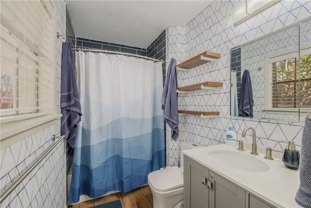 bathroom featuring toilet, curtained shower, vanity, and tile walls