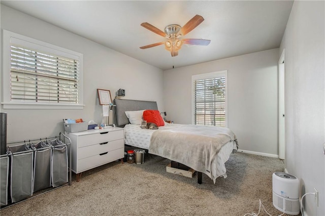 carpeted bedroom with ceiling fan and baseboards