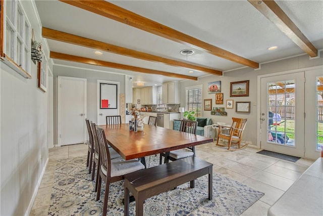 dining room with beam ceiling, light tile patterned flooring, and a wealth of natural light