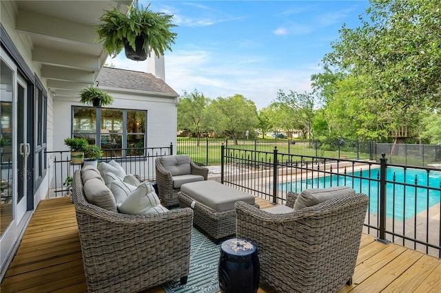 wooden deck with an outdoor living space, fence, and a fenced in pool