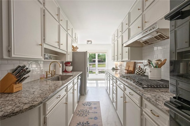 kitchen with white cabinets, a sink, under cabinet range hood, stainless steel gas cooktop, and backsplash