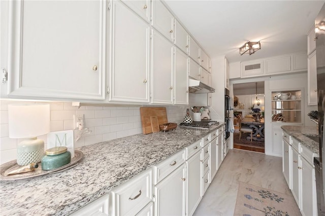 301 Hensel Ave, Bryan, TX 77801 - kitchen featuring white cabinets, backsplash, stainless steel gas cooktop, and light stone countertops