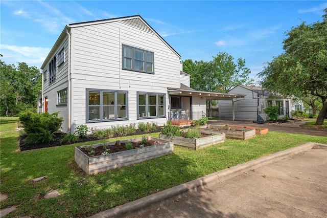 view of front facade with a front lawn and a garden