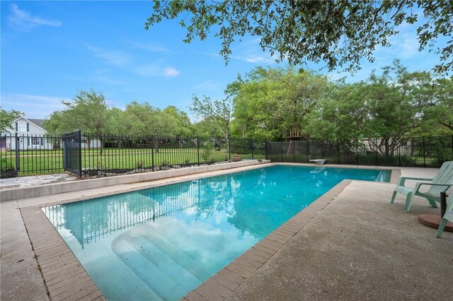 view of pool featuring a lawn, a patio, a fenced in pool, and fence