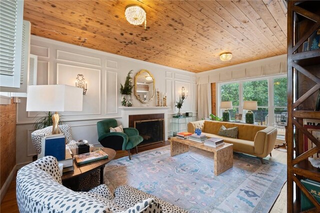 living room featuring wooden ceiling, a decorative wall, and a fireplace