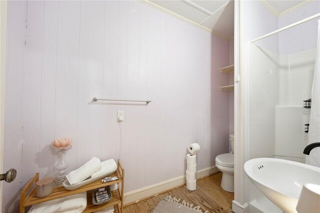 full bath with wood finished floors, a shower, toilet, a sink, and crown molding