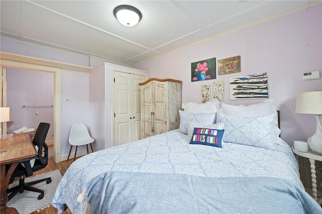 bedroom with wood finished floors and a closet