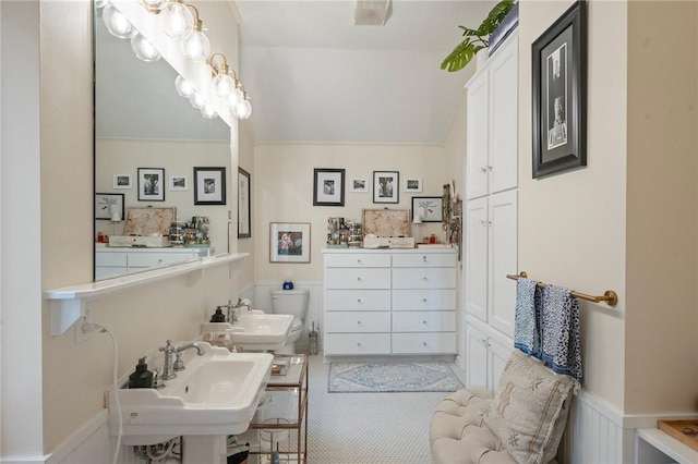 bathroom featuring lofted ceiling and wainscoting