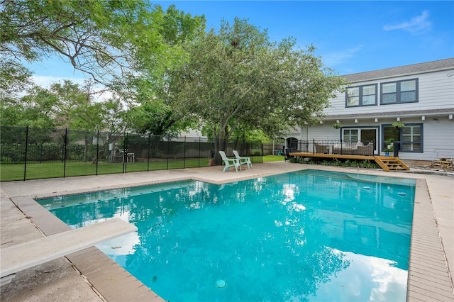 view of swimming pool featuring a wooden deck, a fenced in pool, and fence