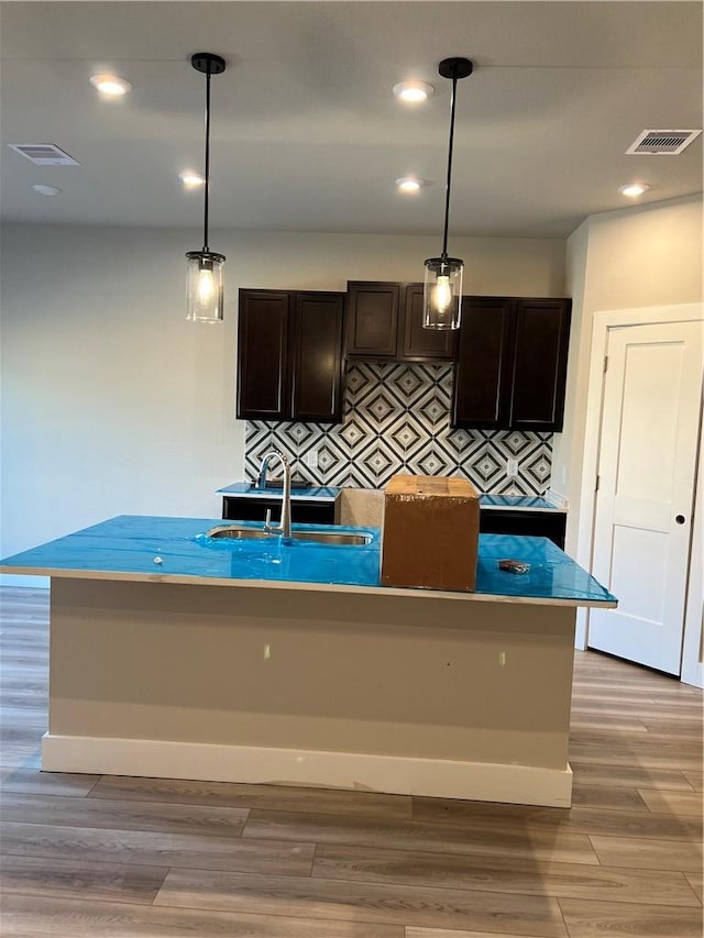 5308 Lyle Pl, Bryan, TX 77807 - kitchen featuring a sink, light wood-style floors, decorative light fixtures, dark brown cabinets, and recessed lighting