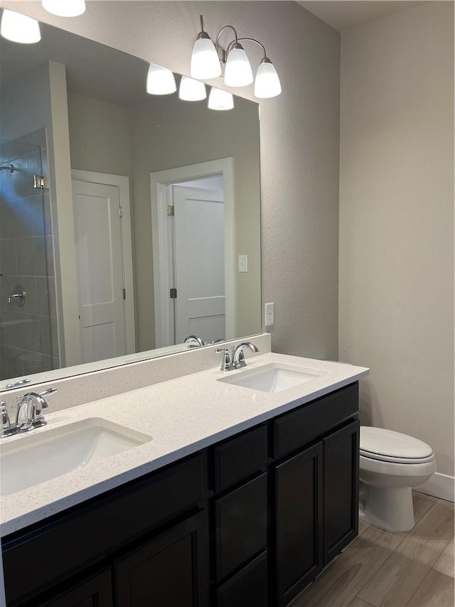 5308 Lyle Pl, Bryan, TX 77807 - bathroom featuring double vanity, toilet, a tile shower, and wood finished floors