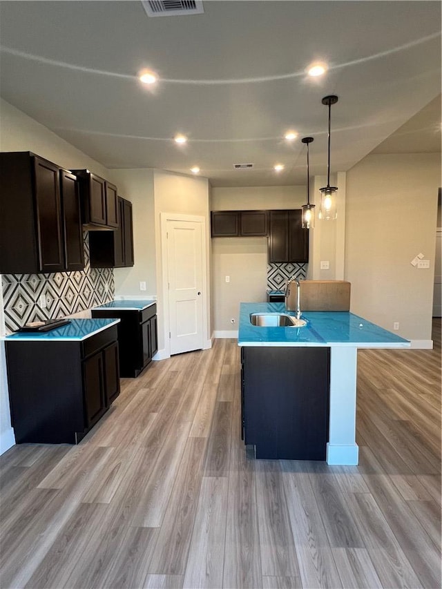 5308 Lyle Pl, Bryan, TX 77807 - kitchen featuring a sink, light wood-style floors, backsplash, baseboards, and recessed lighting