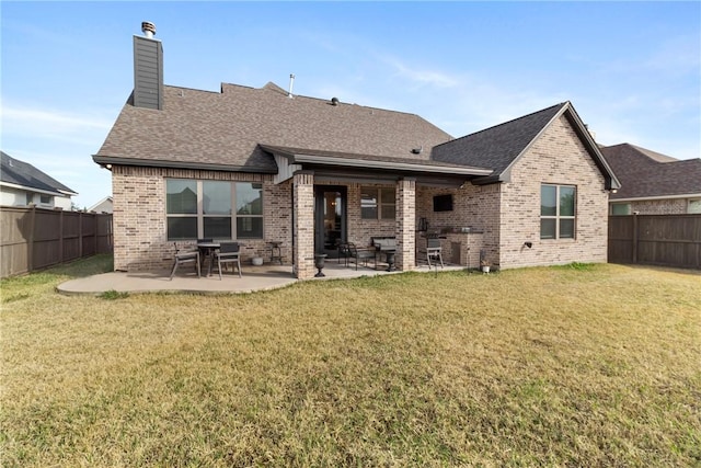 back of house with a patio area and a yard