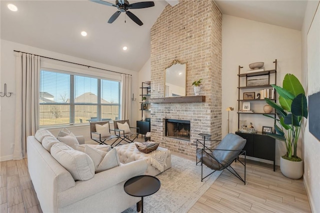 living room featuring a brick fireplace, high vaulted ceiling, a ceiling fan, and wood finished floors