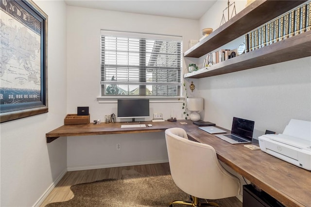 office space featuring light hardwood / wood-style floors and built in desk