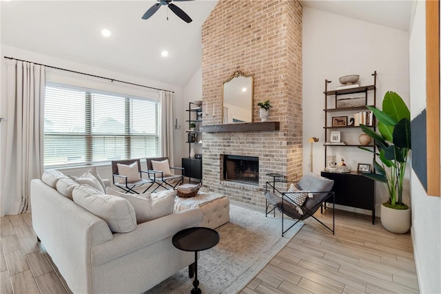 living room with a fireplace, high vaulted ceiling, and ceiling fan