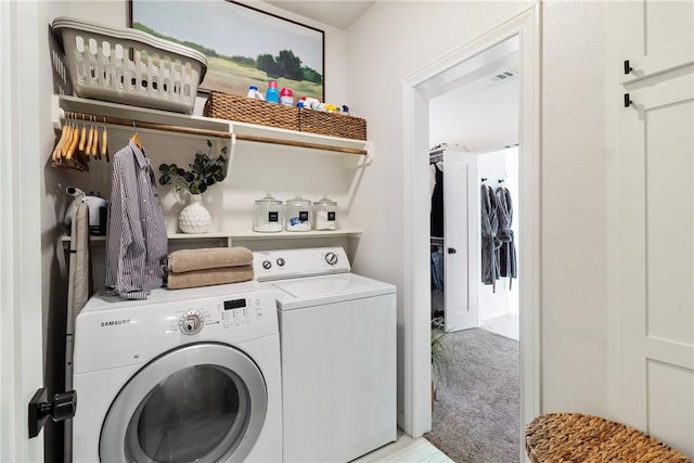 clothes washing area featuring washing machine and dryer and light colored carpet