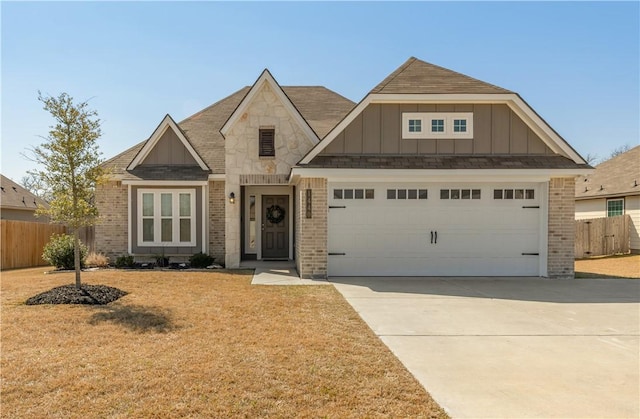 view of front facade with a garage, brick siding, board and batten siding, and fence