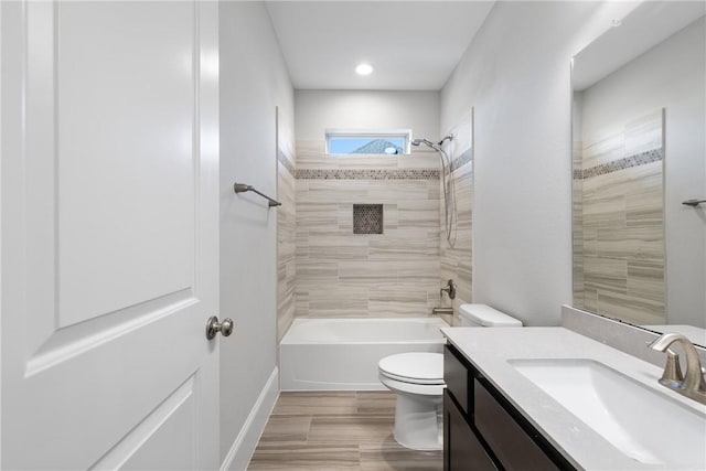 full bathroom featuring hardwood / wood-style flooring, vanity, toilet, and tiled shower / bath