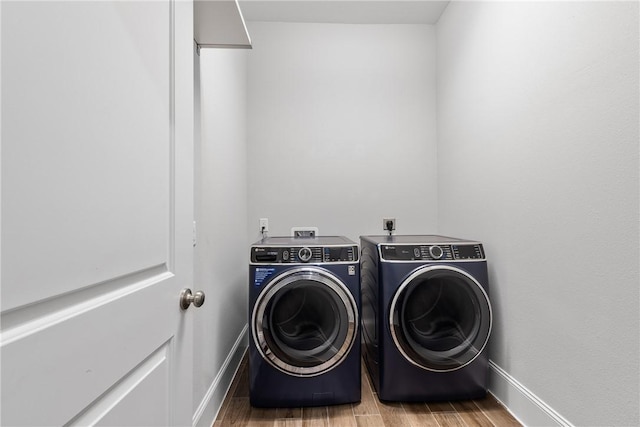 laundry room with hardwood / wood-style floors and washer and dryer