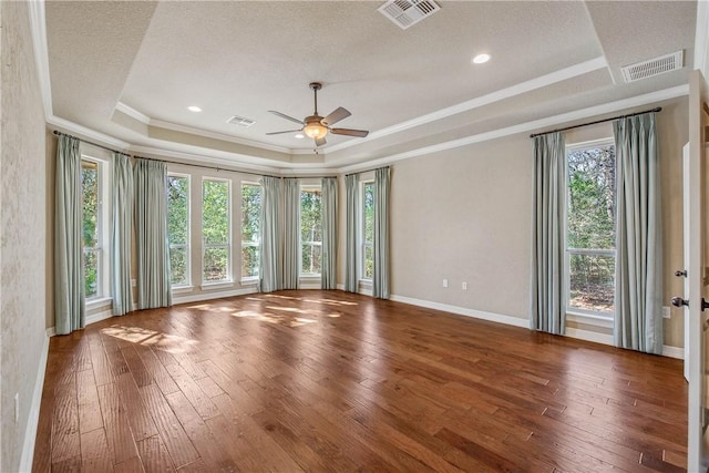 unfurnished room featuring ornamental molding, a textured ceiling, a tray ceiling, ceiling fan, and wood-type flooring