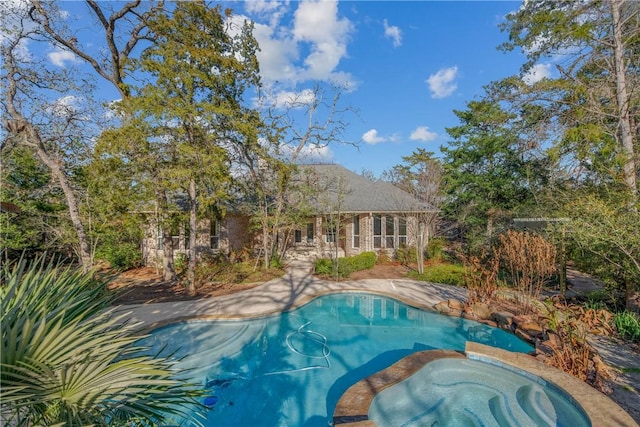 view of swimming pool with an in ground hot tub