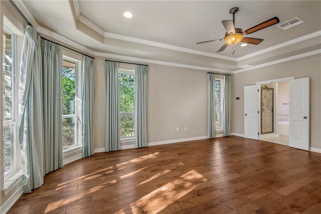 empty room featuring a tray ceiling, ceiling fan, plenty of natural light, and crown molding