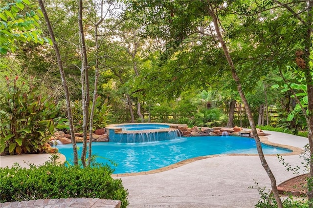 view of swimming pool with pool water feature and an in ground hot tub