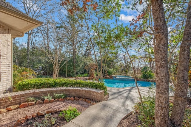 view of swimming pool featuring an in ground hot tub