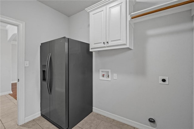 laundry area featuring washer hookup, electric dryer hookup, light tile patterned flooring, and cabinets