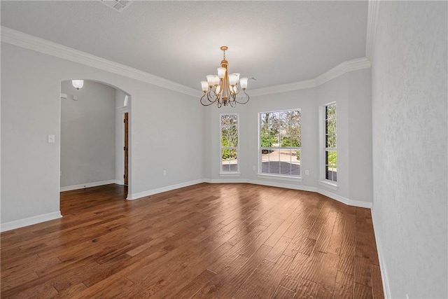 spare room with dark hardwood / wood-style floors, ornamental molding, and a chandelier