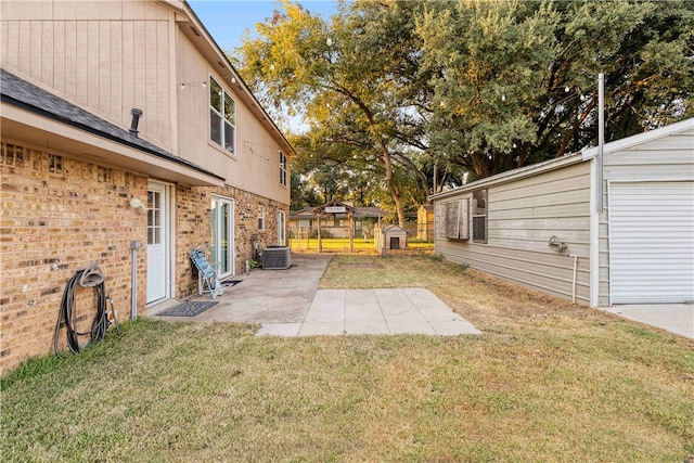 view of yard featuring a patio, central AC unit, and a storage unit