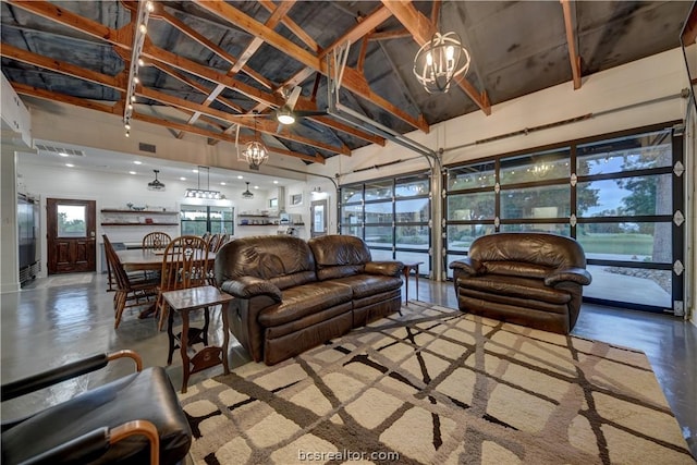 living room with beam ceiling, concrete floors, a water view, and high vaulted ceiling