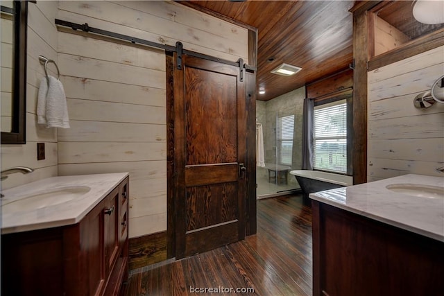 bathroom with hardwood / wood-style floors, vanity, wood ceiling, and wooden walls