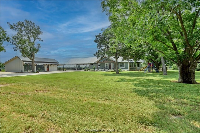 view of yard with a playground and a garage