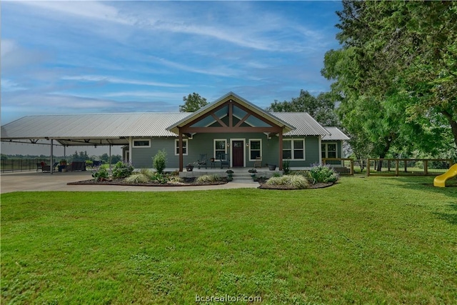 rear view of house featuring a porch and a lawn