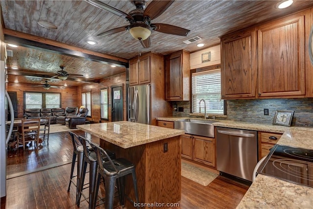 kitchen featuring a wealth of natural light, a center island, dark hardwood / wood-style floors, and appliances with stainless steel finishes