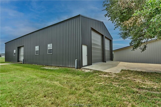 view of outdoor structure with a yard and a garage