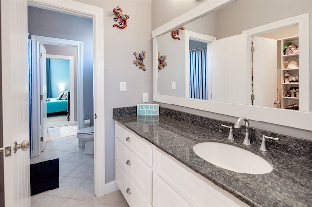 bathroom featuring tile patterned flooring, vanity, and toilet