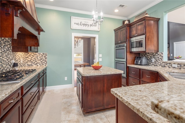 kitchen featuring backsplash, pendant lighting, a chandelier, a kitchen island, and appliances with stainless steel finishes