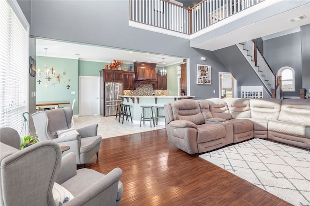 living room featuring hardwood / wood-style floors, a healthy amount of sunlight, and an inviting chandelier