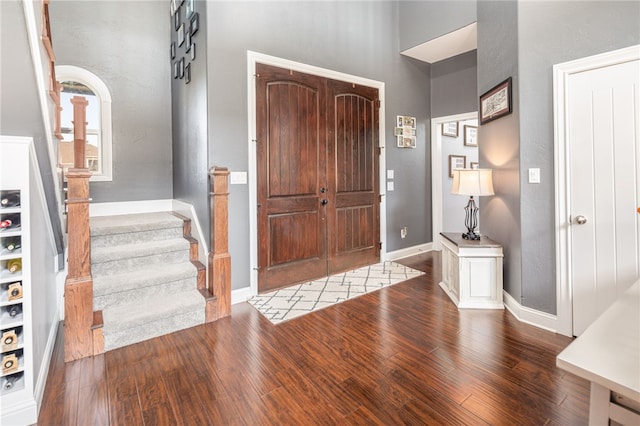 entrance foyer with wood-type flooring and a towering ceiling