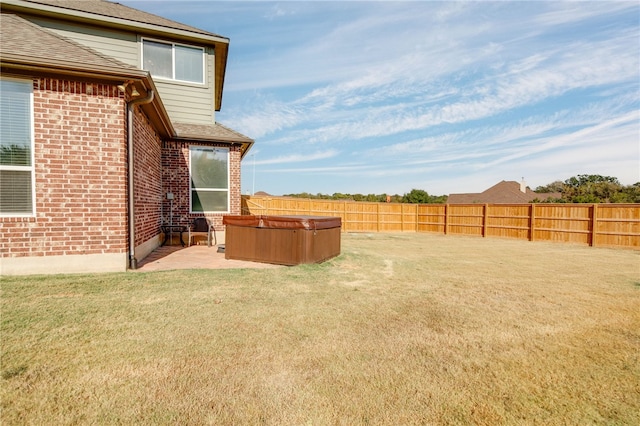 view of yard with a patio area, a hot tub, and a fenced backyard