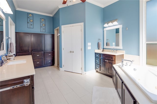 bathroom featuring crown molding, two vanities, a tub with jets, and a sink